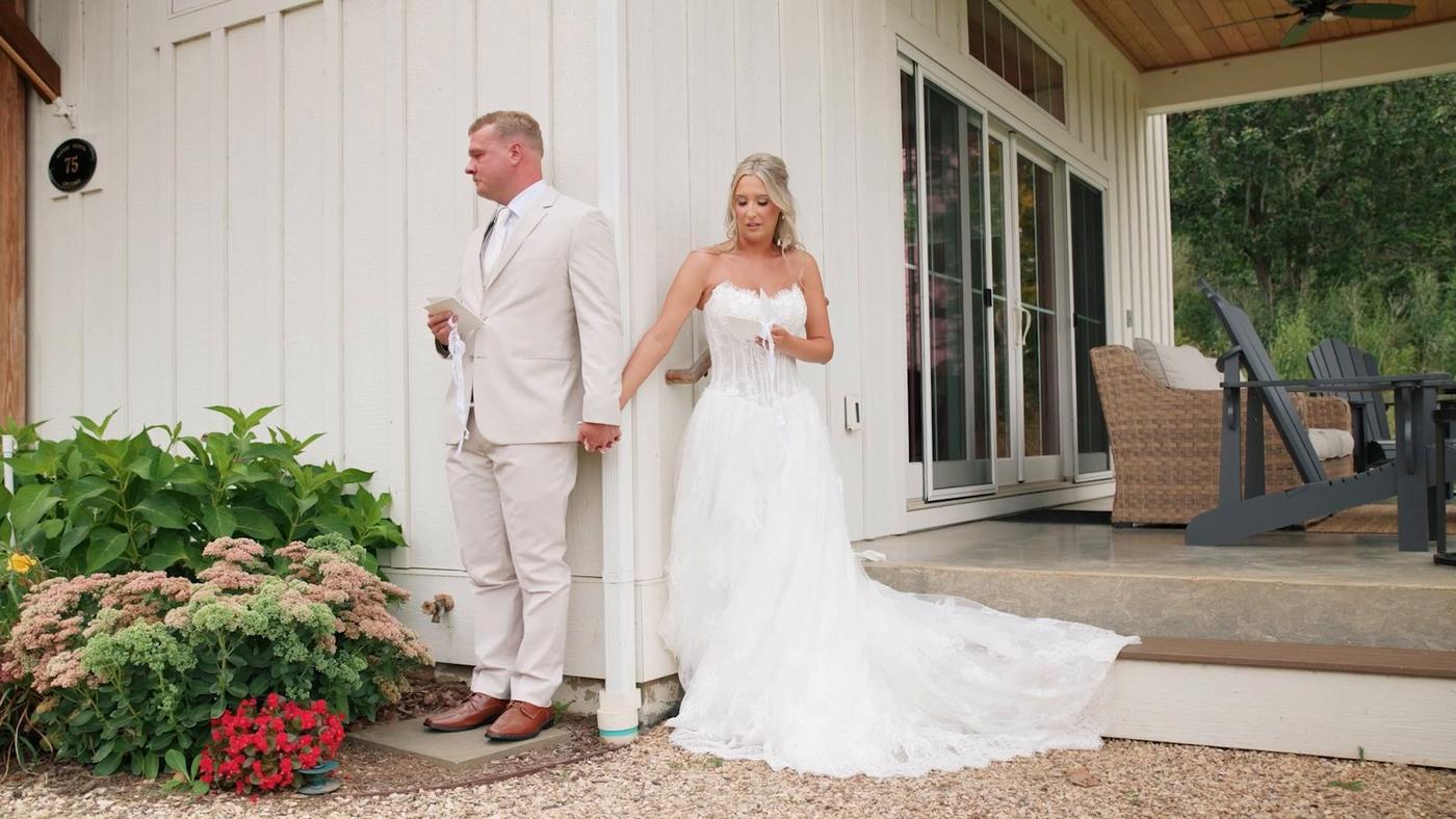 Bride and groom on either side of the farmhouse wall for their first touch at Big Spring Farm